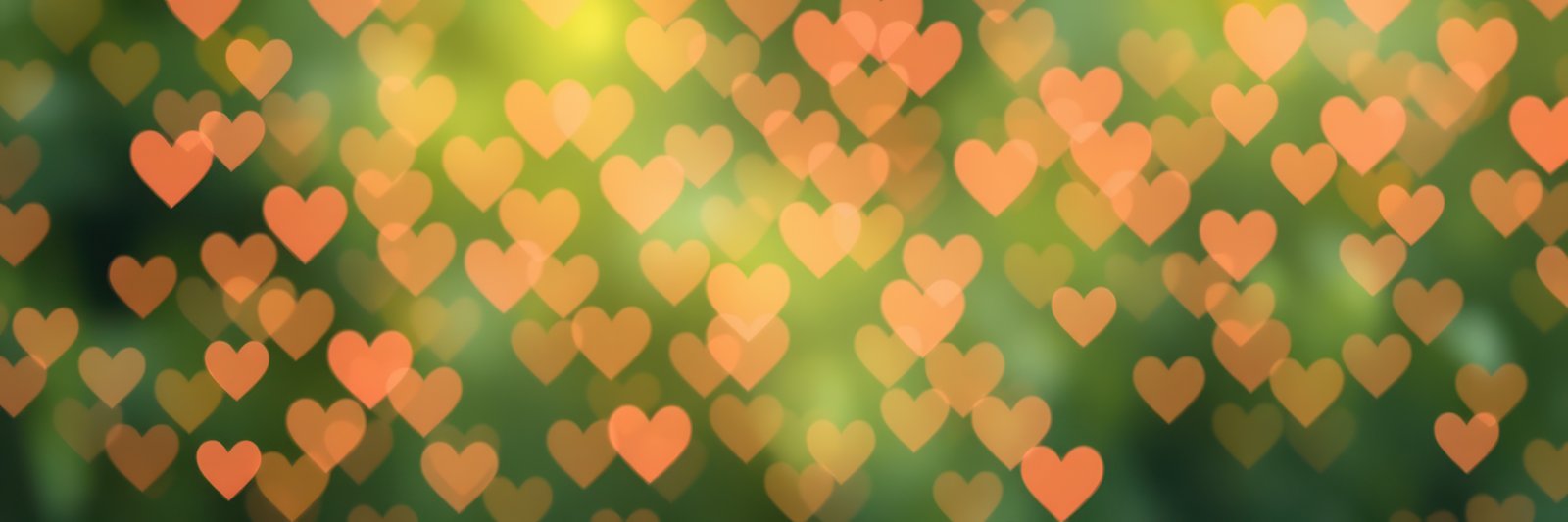 Colorful heart shapes create a vibrant bokeh effect in a lush outdoor setting during daylight hours